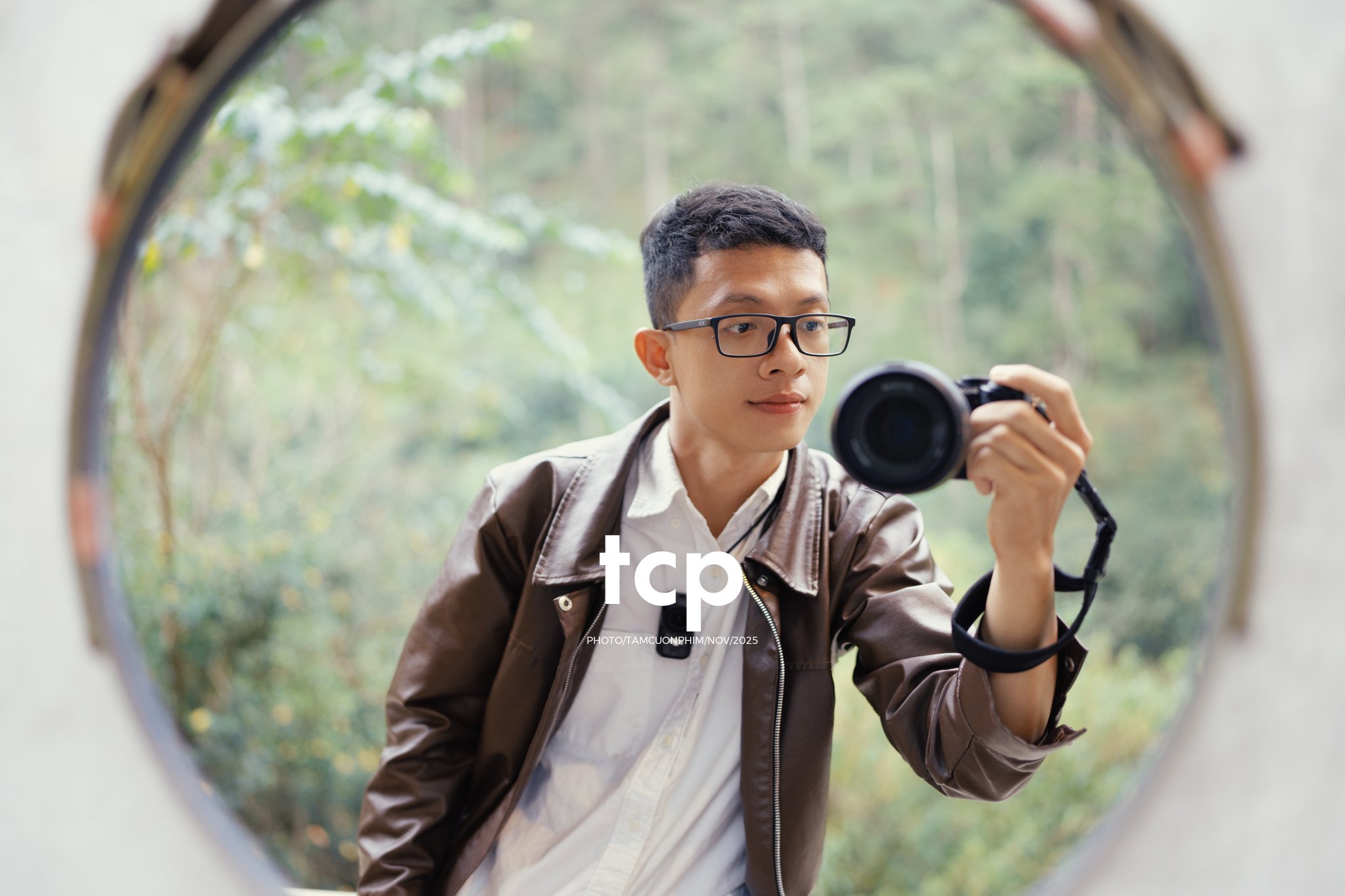 Kha Nguyen, nhiếp ảnh gia của Tám Cuộn Phim, cầm máy ảnh chụp qua tấm gương tròn